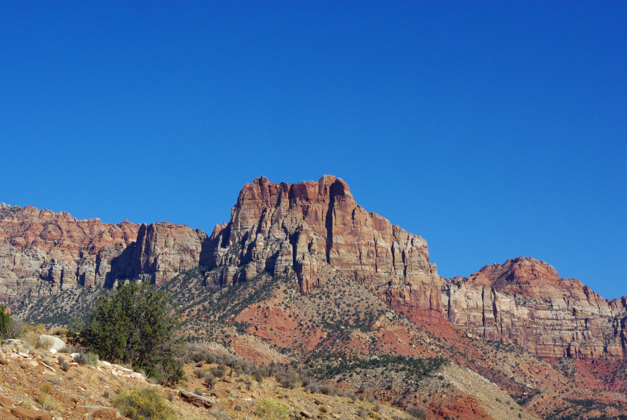 Scenic view of red rock formations under a clear blue sky, representing the natural beauty surrounding Santa Clara, Utah, ideal for custom home building.